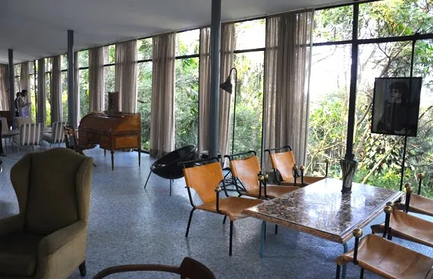 Sala ampla com fechamento de vidro e vista para o jardim
